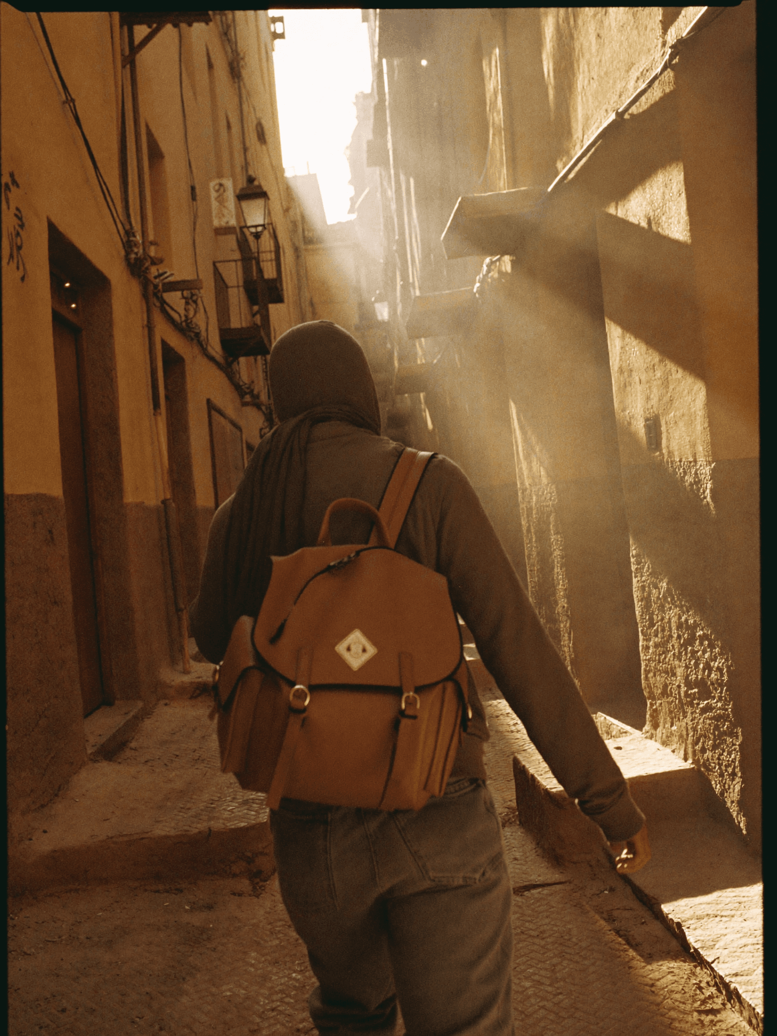 A traveler carrying a LumaFes backpack through a Fes medina